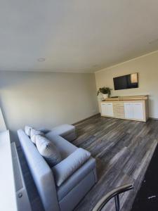 a living room with a blue couch and a flat screen tv at Friendly Apartment in Valmiera