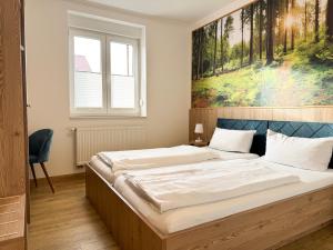 a bedroom with a large bed with a painting on the wall at Heilotel in Heilbad Heiligenstadt