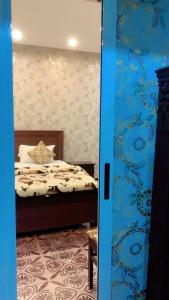 a bedroom with a bed and a blue wall at Green View Inn Hotel in Lahore