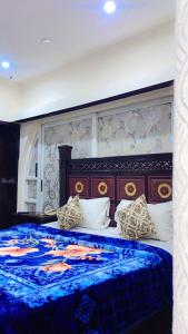 a bedroom with a large bed with a blue blanket at Green View Inn Hotel in Lahore