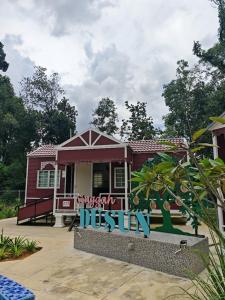 a small red house with a sign in front of it at Singgah Dusun Zahra in Kampong Perak