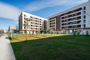 a large building with a park in front of it at APART 28 - Premium Suites in Podgorica