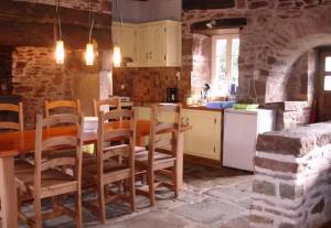 a kitchen with a table and chairs in a room at Gîte Pierre, Beynat, Corrèze in Beynat