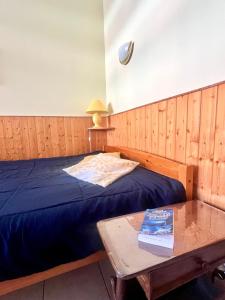 a bedroom with a bed and a table with a book at Résidence thermale de Vernet-les-Bains - balcon, ascenseur, wifi, parking in Vernet-les-Bains
