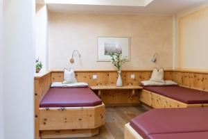 two beds in a room with wooden dividers at Hotel Bischofsmütze in Filzmoos +32 photos