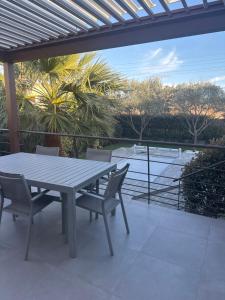 a table and chairs on a patio with a view of a pool at VILLA TRANQUILLE in Fréjus