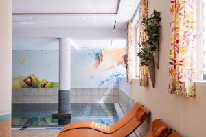 a dining room with a room with a fish tank at Hotel Bischofsmütze in Filzmoos