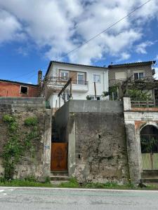a white house with a staircase leading up to a building at Casinhas à Beira Rio in Penacova