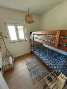 a bedroom with two bunk beds and a window at Casinhas à Beira Rio in Penacova