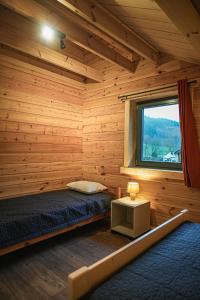 a log cabin with a bed and a window at Gites de la Semois in Laviot +39 photos