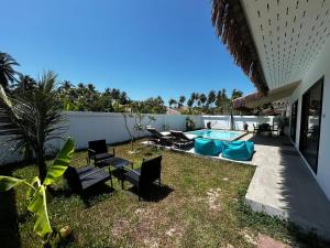 a backyard with a pool and chairs and a table at Villa L Aurora in Taling Ngam Beach