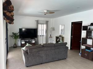a living room with a couch and a flat screen tv at Villa L Aurora in Taling Ngam Beach
