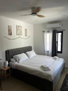 a bedroom with a large bed with a ceiling fan at Villa L Aurora in Taling Ngam Beach +13 photos
