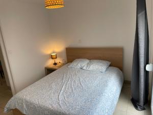 a bedroom with a bed with a blue comforter at Eiffel in Haubourdin