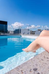 Una mano se mete en una piscina en Onyx Hotel, en San Julián
