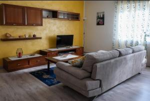 a living room with a couch and a tv at Casa Sacchet a Longarone in Longarone