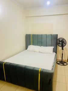 a bed with a blue headboard in a room at Haven one bedroom in Busia