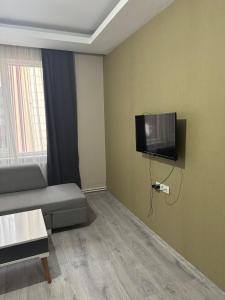 a living room with a couch and a flat screen tv at Blue class otel in Atakum