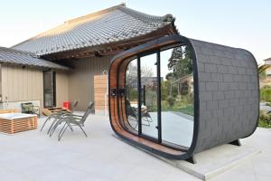 a circular mirror on a patio with a table and chairs at 愛敬家 in Mobara