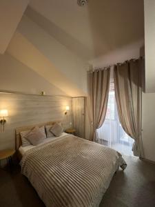 a bedroom with a large bed and a window at PENSIUNEA UNO in Timişoara