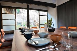 a long wooden table with bowls and utensils on it at 愛敬家 in Mobara