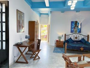 a bedroom with a bed and a desk and a table at Résidence Soros - Île de Gorée in Dakar