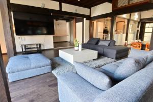 a living room with blue couches and a tv at 愛敬家 in Mobara