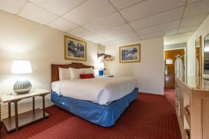 a hotel room with a large bed and a bathroom at Fireside Inn and Suites Bangor in Bangor