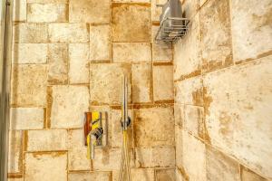 a shower with a faucet on a stone wall at Corte Piri in Tricase +82 photos