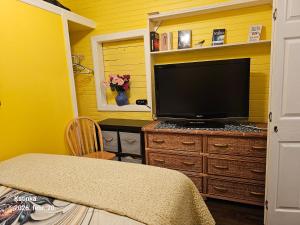 a television on a dresser in a room with yellow walls at 2#studio In Clearwater usa in Clearwater