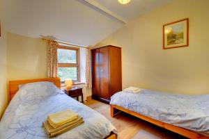 a bedroom with two beds and a window at 3 Bed in Dolgellau oc-wah464 in Llanfachreth