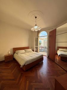 a bedroom with a bed and a large window at Appartamento Bixio sul porto in Sanremo