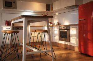 a kitchen with a bar with stools in it at Pomme d'Happy in Autheux