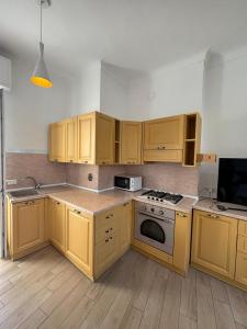 a kitchen with wooden cabinets and a stove top oven at Appartamento Bixio sul porto in Sanremo +15 photos