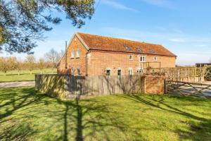 an old brick house with a fence in a yard at 3 Bed in Knodishall oc-wbco in Aldringham