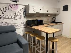 a kitchen with a counter with stools and a microwave at Studio Music Blue - Bourgoin Centre in Bourgoin
