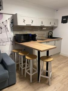 a kitchen with a counter with stools and a microwave at Studio Music Blue - Bourgoin Centre in Bourgoin +5 photos