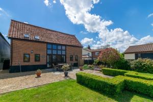 a brick house with a garden in front of it at 3 Bed in Little Ellingham oc-2147 in Rockland Saint Peter