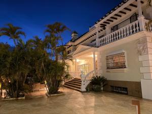 a large white house with stairs and palm trees at CASABA - Boutique - Torre del Mar in Torre del Mar