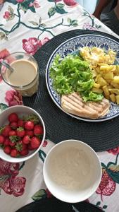 a table with a plate of food and a bowl of fruit at Ka'Zinha Guesthouse - Chambres d'hôtes Tarrafal in Tarrafal
