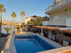 a swimming pool in front of a building with a house at Infinity Blue Korčula in Korčula