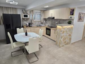 a kitchen with a white table and white chairs at Infinity Blue Korčula in Korčula
