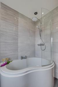 a white bath tub in a bathroom with a shower at 3 Bed in Ravenscar oc-sa397 in Ravenscar +10 photos
