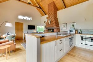 a kitchen with white cabinets and a brick fireplace at 3 Bed in Debenham oc-thefol in Debenham