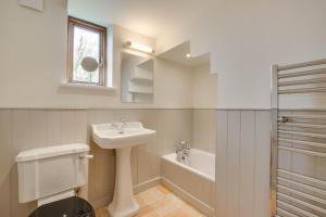 a bathroom with a sink and a toilet and a tub at 3 Bed in Debenham oc-thefol in Debenham +5 photos