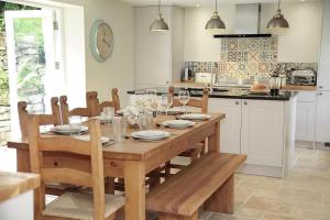 a kitchen with a wooden table with glasses of wine at 4 Bed in Gower oc-hh471 in Llanmadoc