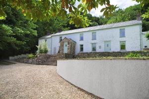 a large white house with a stone wall at 4 Bed in Gower oc-hh471 in Llanmadoc