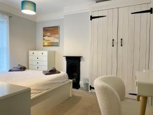 a bedroom with a bed and a chair and a fireplace at 3 Bed in Winterton-on-Sea oc-2205 in Winterton-on-Sea
