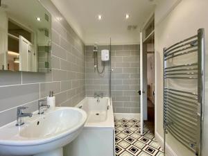a bathroom with a sink and a bath tub at 3 Bed in Winterton-on-Sea oc-2205 in Winterton-on-Sea +19 photos