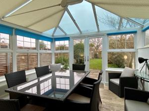 a conservatory with a glass table and chairs at 3 Bed in Winterton-on-Sea oc-2205 in Winterton-on-Sea